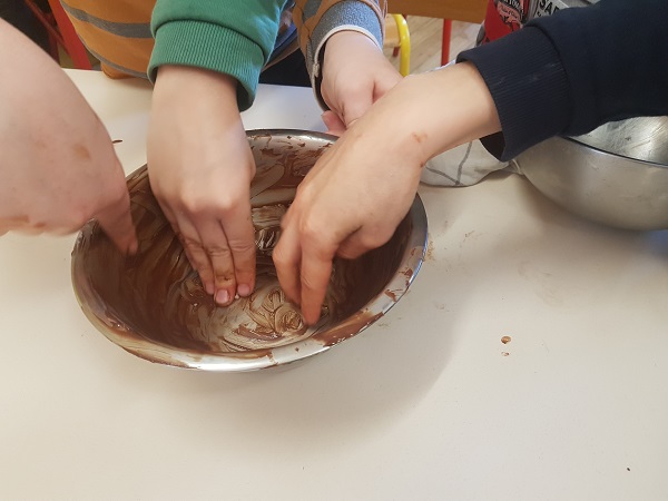 Enfants trempent mains chocolat
